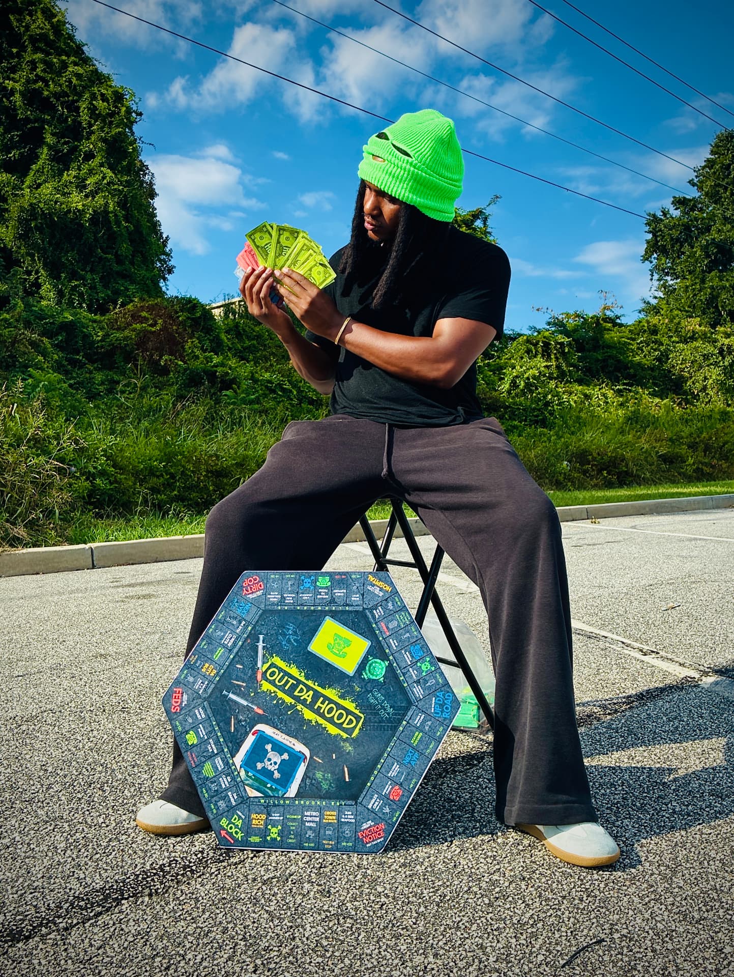 Founder holding cash with the Out Da Hood board game